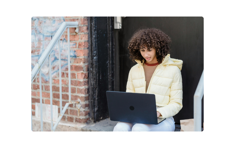 Young woman using a laptop outdoors, representing digital brand creation and strategies for building an online presence. 